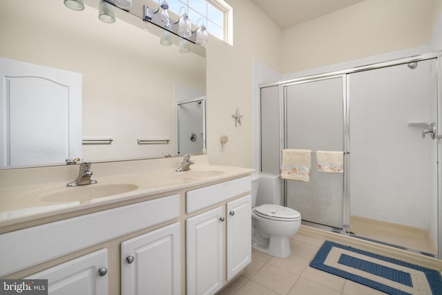 bathroom with double vanity, a stall shower, tile patterned flooring, and a sink