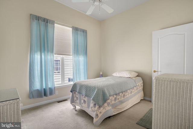 carpeted bedroom with a ceiling fan, visible vents, and baseboards