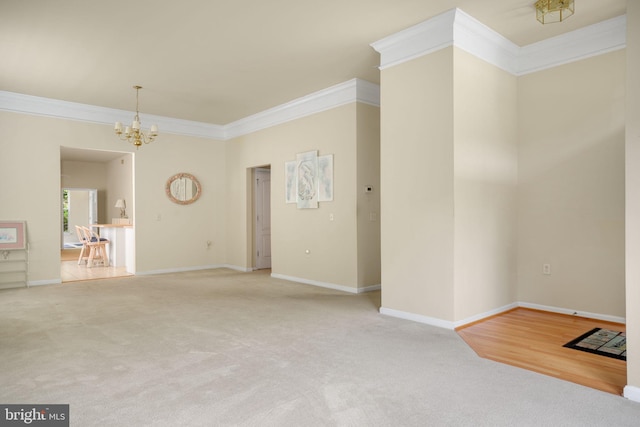 unfurnished living room featuring baseboards, ornamental molding, a notable chandelier, and carpet flooring