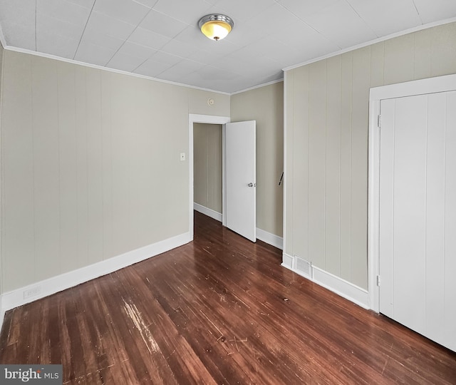 spare room featuring hardwood / wood-style flooring and ornamental molding