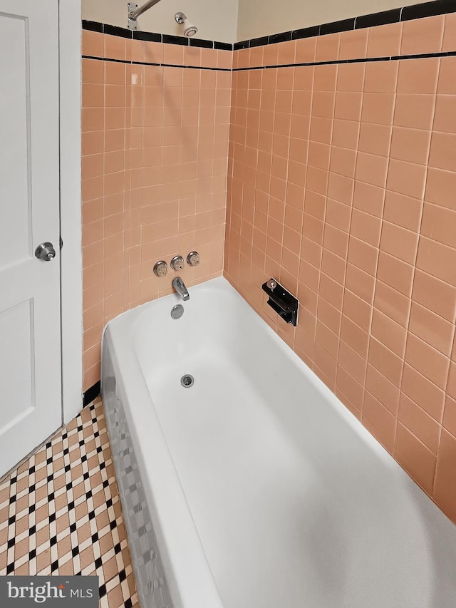 bathroom with tile patterned flooring, tile walls, and tiled shower / bath