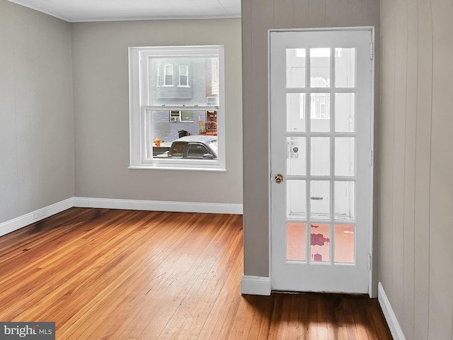 doorway to outside with baseboards and wood-type flooring