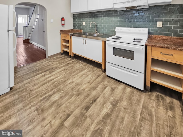 kitchen featuring white appliances, white cabinets, sink, light hardwood / wood-style floors, and decorative backsplash