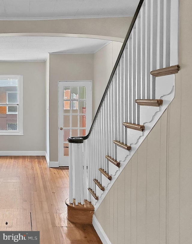 staircase with crown molding, baseboards, and hardwood / wood-style flooring