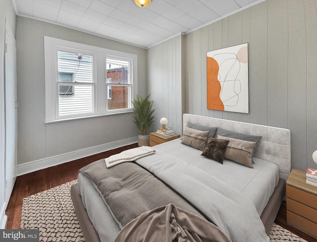 bedroom with baseboards, wood finished floors, and ornamental molding