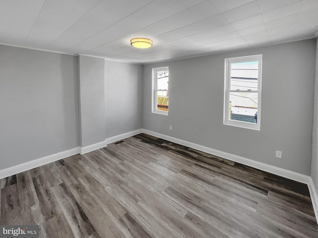 unfurnished room featuring wood-type flooring and ornamental molding