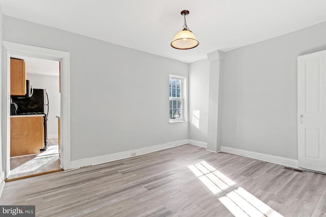 spare room with light hardwood / wood-style flooring