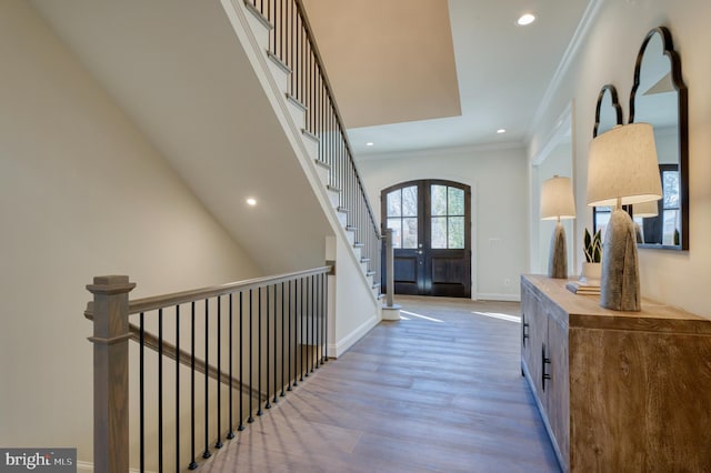 hall featuring crown molding, hardwood / wood-style flooring, and french doors