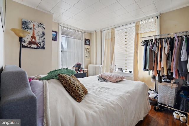 bedroom featuring radiator, dark hardwood / wood-style flooring, and ornamental molding