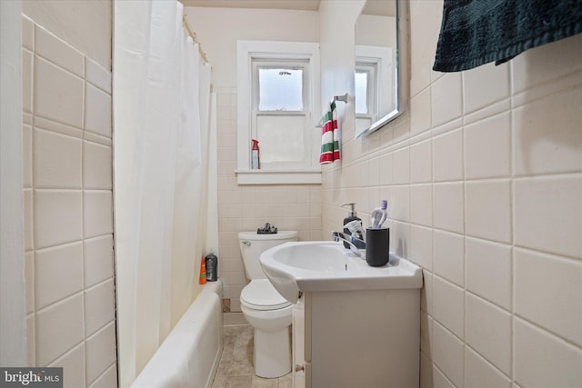 bathroom featuring vanity, toilet, and tile walls