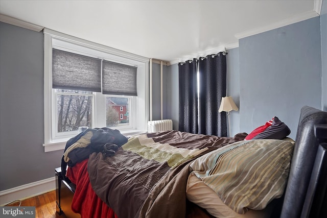 bedroom featuring radiator, crown molding, and wood-type flooring