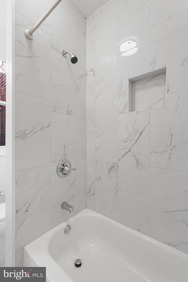 bathroom featuring tiled shower / bath