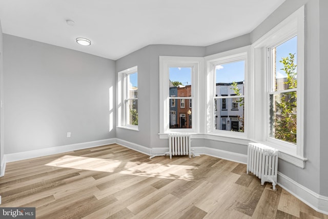 unfurnished room with light hardwood / wood-style flooring and radiator