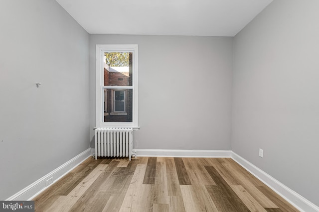 spare room featuring light hardwood / wood-style floors and radiator heating unit