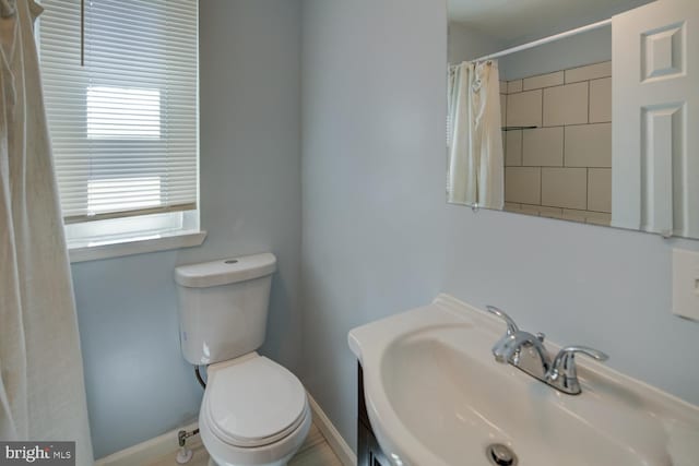 bathroom with sink, a shower with shower curtain, and toilet