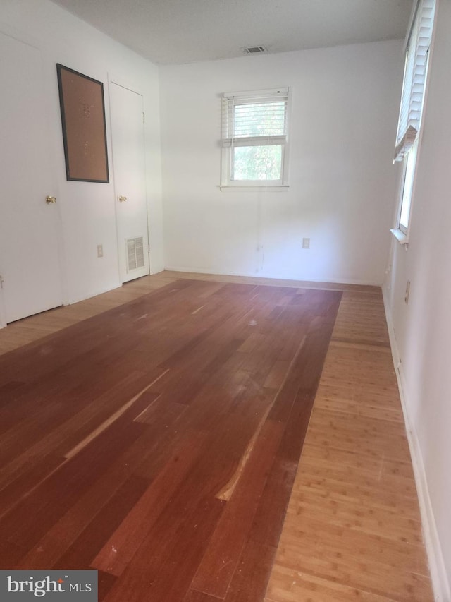 unfurnished room with visible vents and light wood finished floors