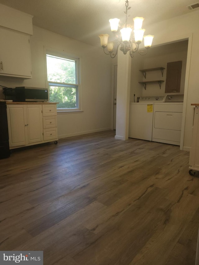 unfurnished dining area with visible vents, a notable chandelier, separate washer and dryer, and dark wood-style flooring