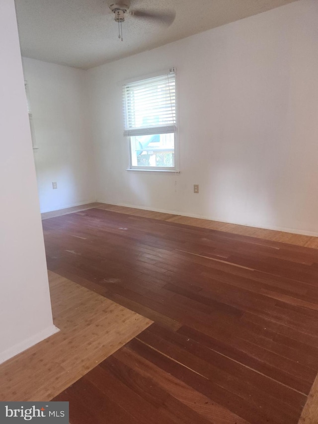 empty room with baseboards, ceiling fan, and wood finished floors