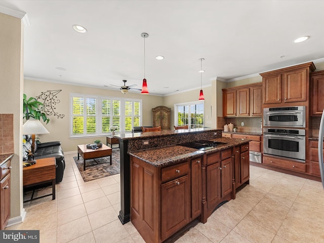 kitchen with ceiling fan, cooktop, dark stone countertops, decorative light fixtures, and light tile patterned floors