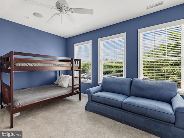 bedroom with light carpet, multiple windows, and ceiling fan