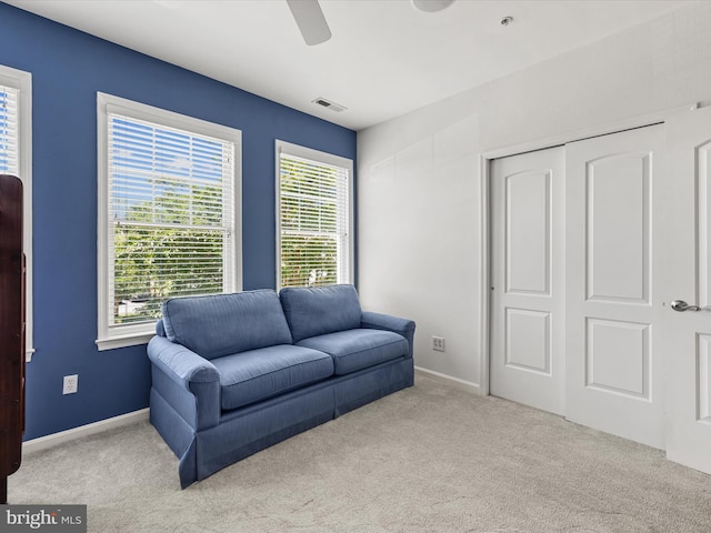 interior space with ceiling fan and light carpet