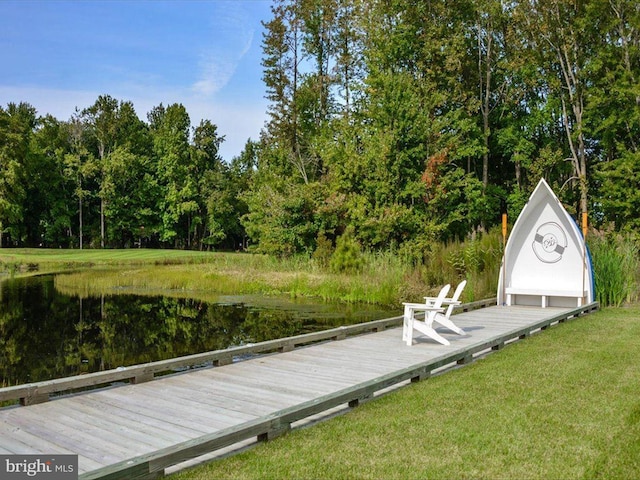 view of dock with a lawn and a water view