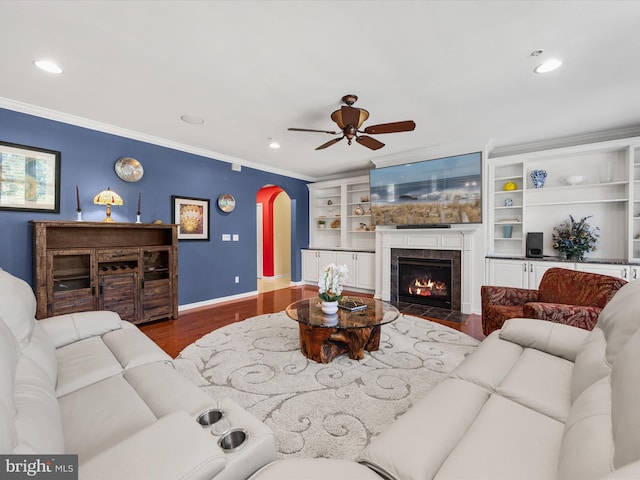 living room featuring ceiling fan, wood-type flooring, and crown molding