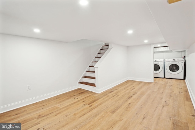 laundry room featuring washing machine and dryer and light hardwood / wood-style floors