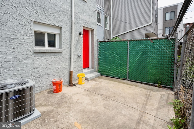 property entrance with a patio area and central air condition unit