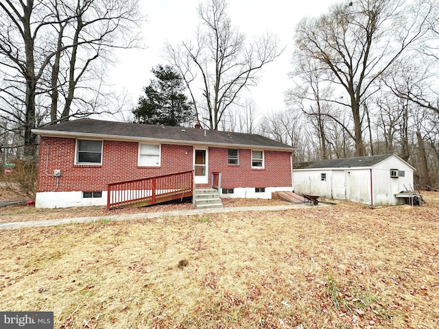 rear view of house featuring a wooden deck and an outdoor structure