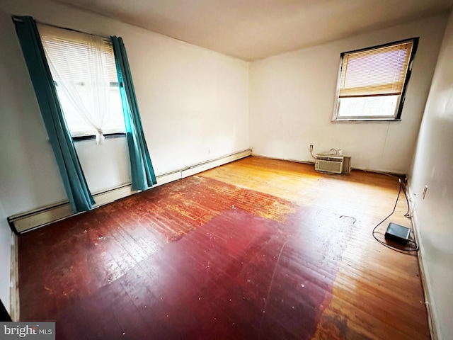 unfurnished room featuring wood-type flooring and an AC wall unit