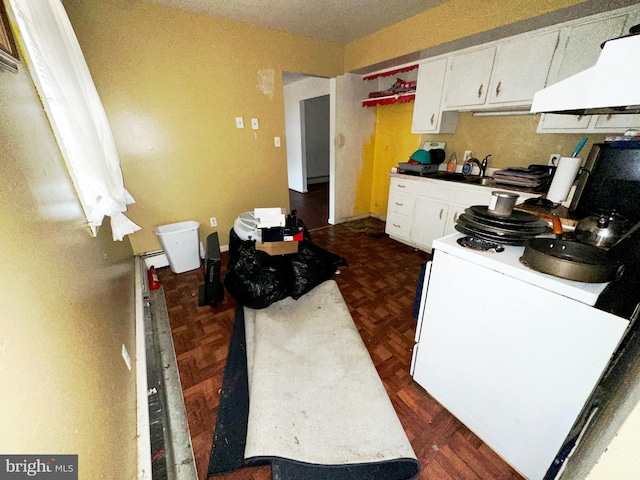 kitchen featuring dark parquet flooring, white cabinetry, white range, and ventilation hood