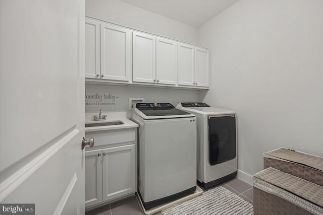 laundry room featuring washing machine and clothes dryer, tile patterned flooring, cabinets, and sink