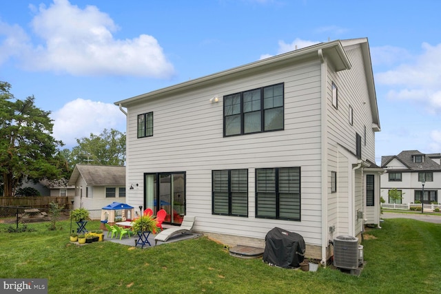 back of property with a lawn, central AC unit, and a patio