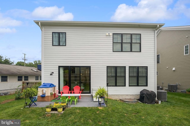 back of house featuring central air condition unit, a patio area, and a yard