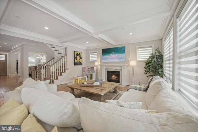 living room featuring beam ceiling, light hardwood / wood-style flooring, a wealth of natural light, and a premium fireplace