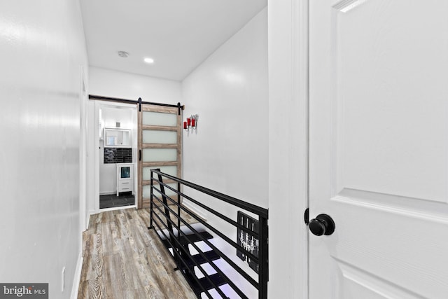 hall featuring hardwood / wood-style floors and a barn door