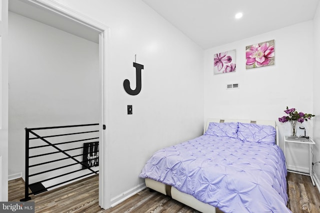 bedroom with dark hardwood / wood-style flooring