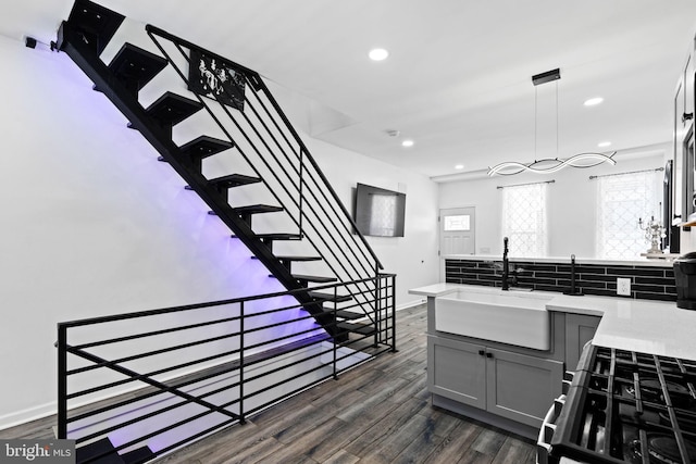 staircase with sink and wood-type flooring