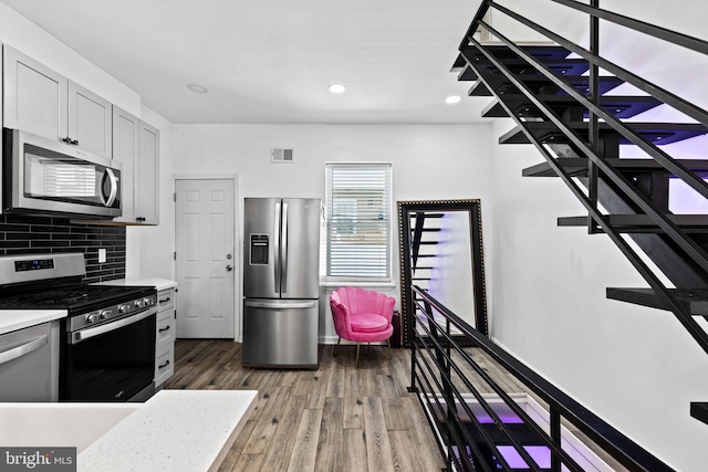 kitchen featuring decorative backsplash, stainless steel appliances, and dark hardwood / wood-style floors