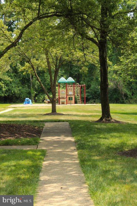 view of property's community with a playground and a lawn