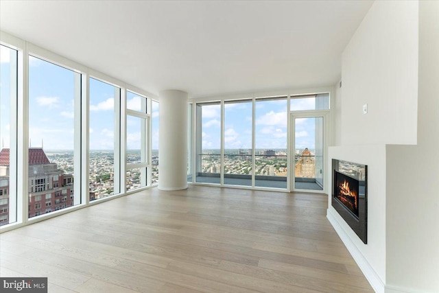 unfurnished living room featuring floor to ceiling windows and light hardwood / wood-style floors