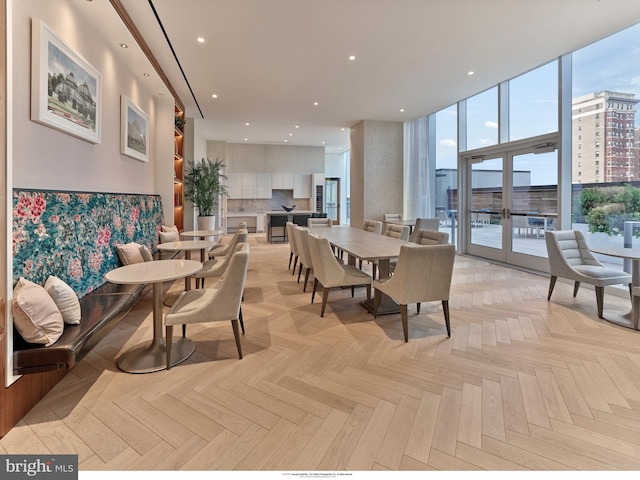 dining room with light parquet flooring and a wall of windows