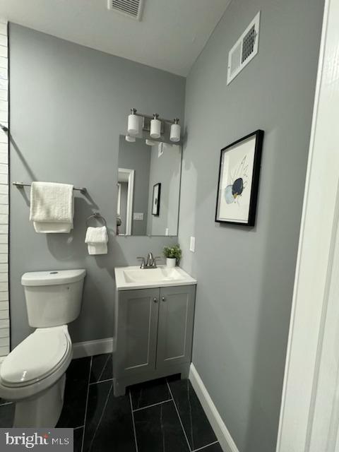 bathroom featuring tile patterned floors, vanity, and toilet