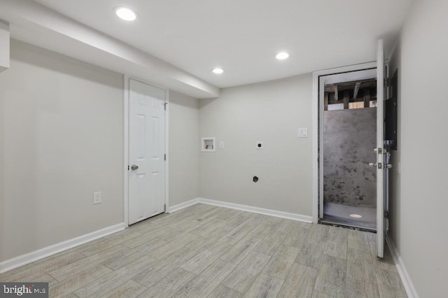 clothes washing area with electric dryer hookup, washer hookup, and light wood-type flooring