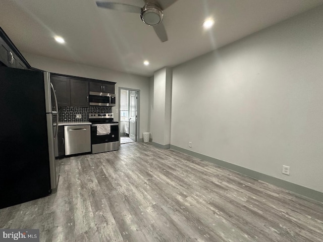 kitchen with decorative backsplash, appliances with stainless steel finishes, light wood-type flooring, and ceiling fan