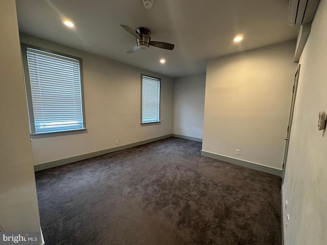 carpeted empty room featuring a wall mounted AC and ceiling fan