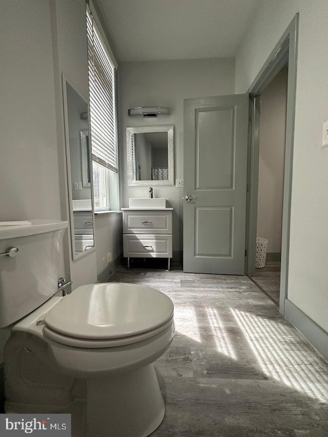 bathroom featuring hardwood / wood-style floors, vanity, and toilet