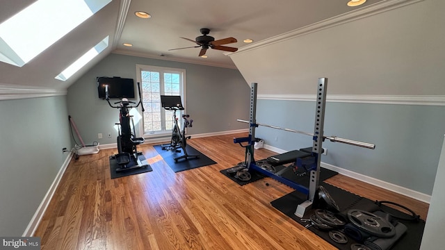 workout room with ornamental molding, lofted ceiling with skylight, hardwood / wood-style floors, and ceiling fan