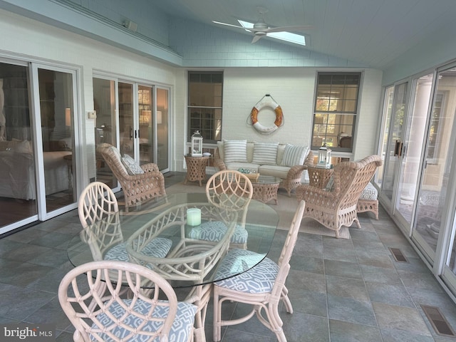 sunroom / solarium with vaulted ceiling with skylight and ceiling fan